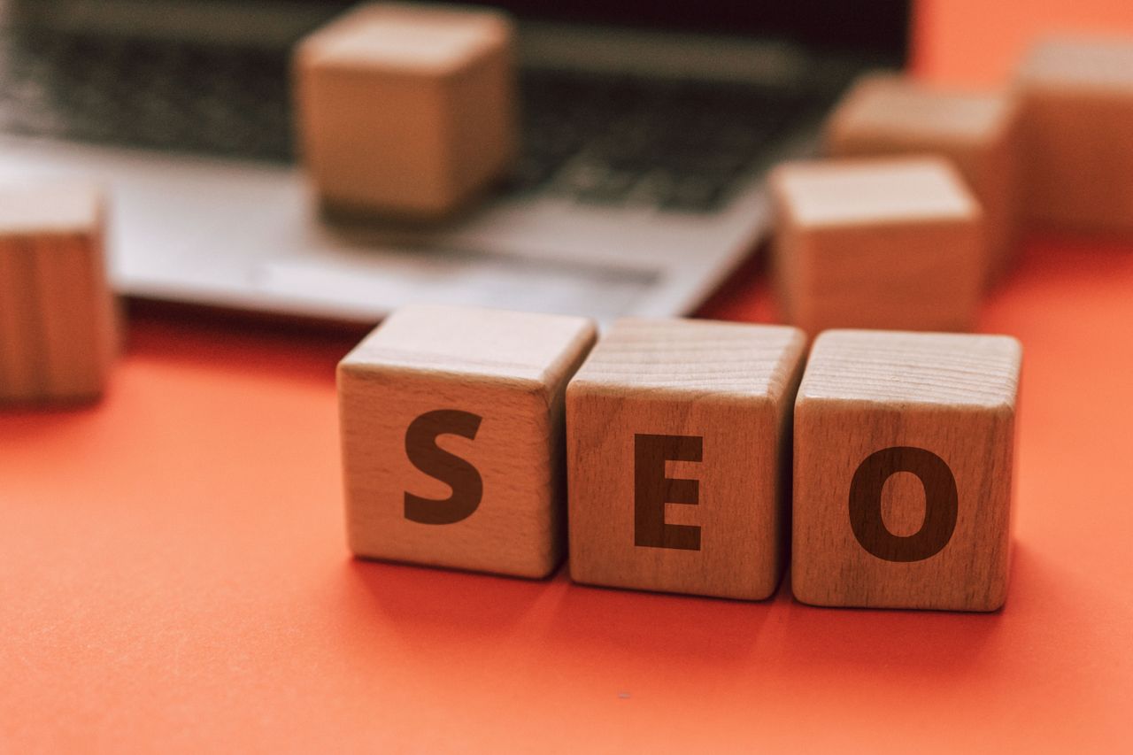 Des blocs en bois formant SEO sur un clavier d’ordinateur portable illustrent des notions de marketing numérique.